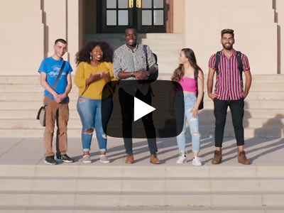 Take a Student-Led Campus Tour | Select to access video A group of UCR students, female and male, stand on the steps of building on campus. There is a video play button overlaid in the center.
