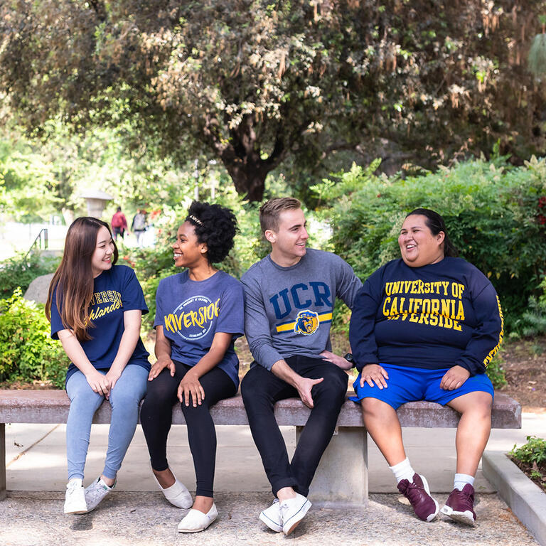 Group of UCR students sitting together near Hinderaker Hall